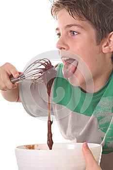 Young boy licking chocolate ba