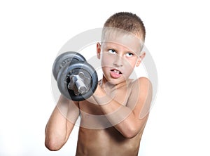 Young boy lifting a very heavy dumbbell