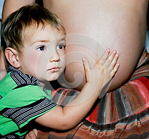 Young boy listening to unborn baby