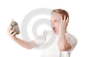 Young boy look the alarm clock over the white