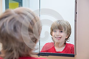 Young boy looking at himself in mirror