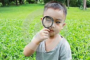 Young boy looking through magnifying glass