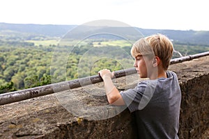 Young Boy Looking Out over Ledge of Tourist Scenic Cliff Viewing