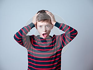 Young boy looking surprised with his hands up