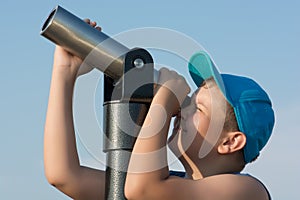 Young boy looking through a telescope