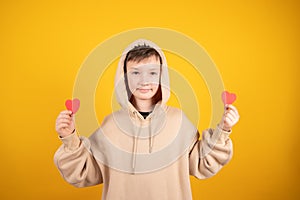 Young boy in love. Portrait of smilling caucasian teen boy in romantic mood, dressed in biege hoodie.