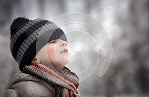 Young boy making water vapour from his mouth