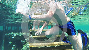 Young boy with mask and tube first time snorkeling in red sea near coral reef