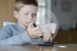 Young boy measure glucose level