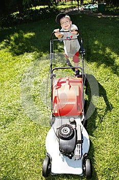 Young boy mowing grass