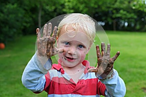 Young boy with muddy hands photo