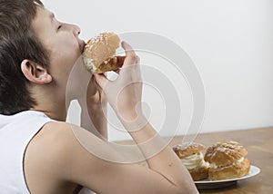 Young boy munching on a cream bun