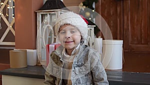 A young boy in a New Year`s hat looks at the camera. Waiting for the holiday concept