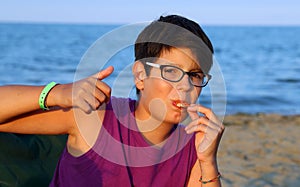 Young boy OK sign with thumb up eating pizza