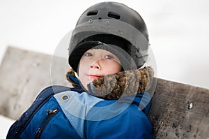 Young boy outdoors wearing a hockey helmet