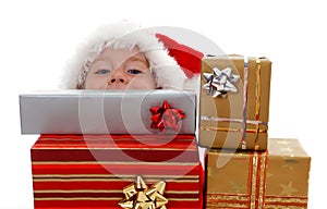 Young boy peeking above gifts