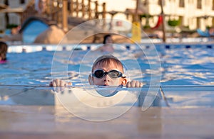 Young boy peering out of a swimming pool