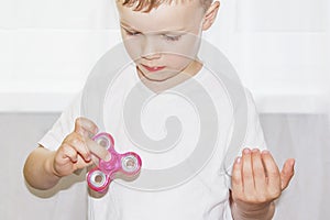 Young boy play with fidget spinner stress relieving toy. Popular toy