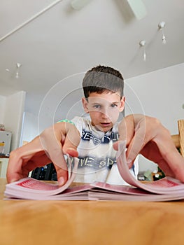 Young boy playing with cards in the kitchen. Selective focus.