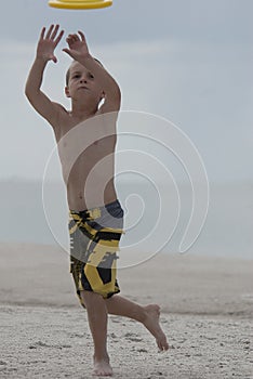 Young boy playing catch on the beach great focus