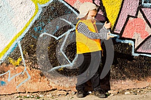 Young boy playing in front of colourful graffiti