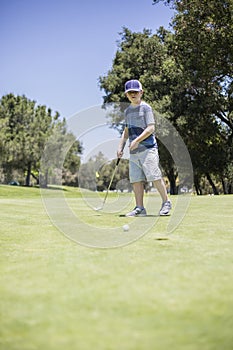 Young boy playing golf