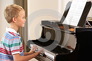 Young boy playing grand piano