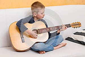 A young boy is playing guitar