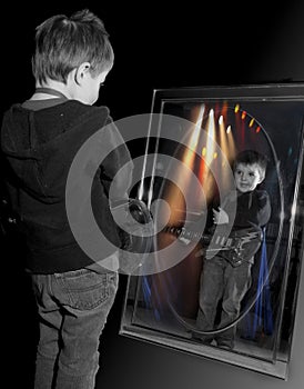 Young boy playing guitar in mirror.