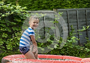 Young boy playing in an inflatable pool