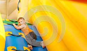 Young boy playing in an inflatable slide