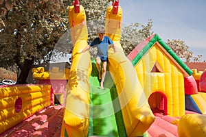 Young boy playing in an inflatable toy house in a park