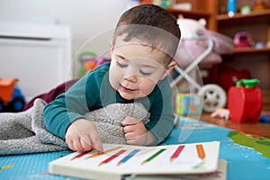 young boy playing and looking at books in his room