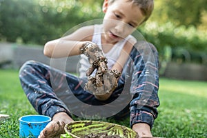 Young boy playing with mud