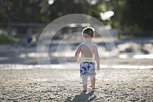 Young boy playing on the mudflats in the setting sun