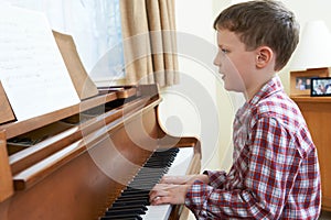 Young Boy Playing Piano At Home