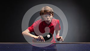 Young boy playing ping pong table tennis