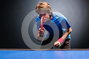 Young boy playing ping pong table tennis