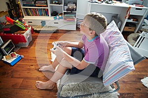 Young Boy Playing Video Game In Bedroom