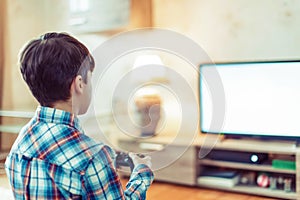 Young boy playing video game on console empty space