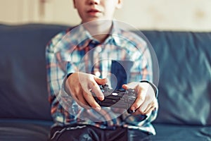 Young boy playing video game by controller closeup