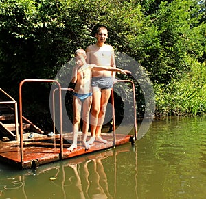 A young boy plays with his older brother in the water