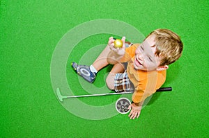 Young boy plays mini golf