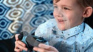 Young boy plays video game with joystick and showing lots of emotions