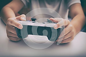 Young boy plays video game using a gamepad