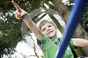 Young Boy Pointing Away On Monkey Bars