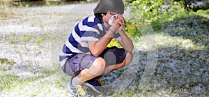 Young boy with pollen allergy with handkerchief photo