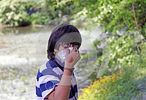 Young boy with pollen allergy with white handkerchief