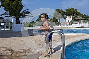 Young Boy by Poolside with Palm Trees