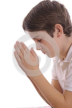 Young boy praying on white vertical